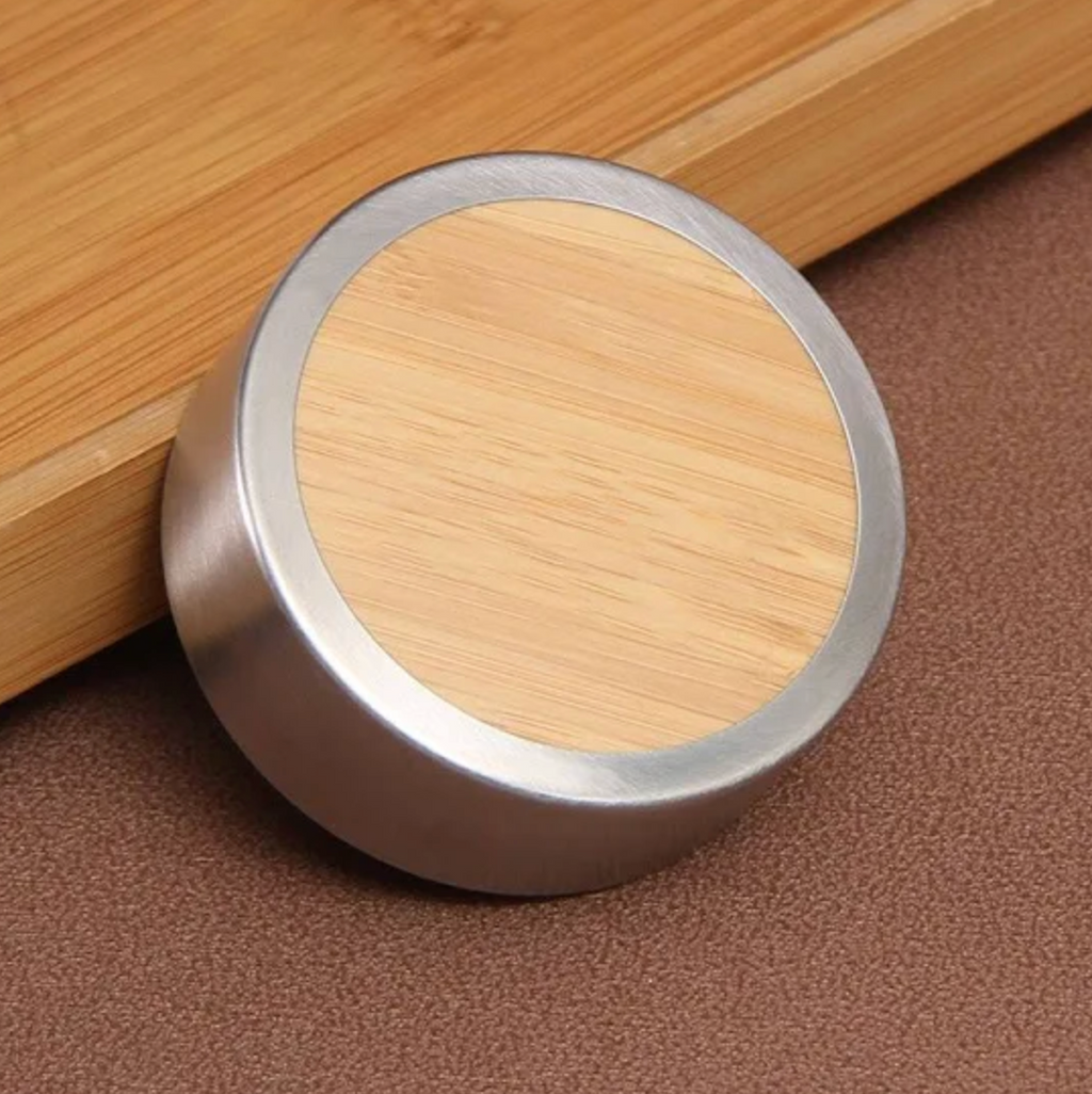 Round bamboo lid with metallic rim on a wooden surface