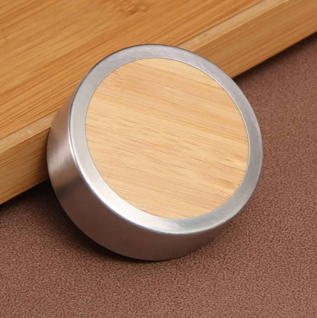Round bamboo lid with metallic rim on a wooden surface