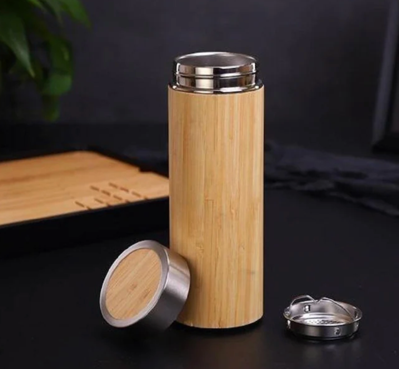 Bamboo water bottle with bamboo cap on a dark background