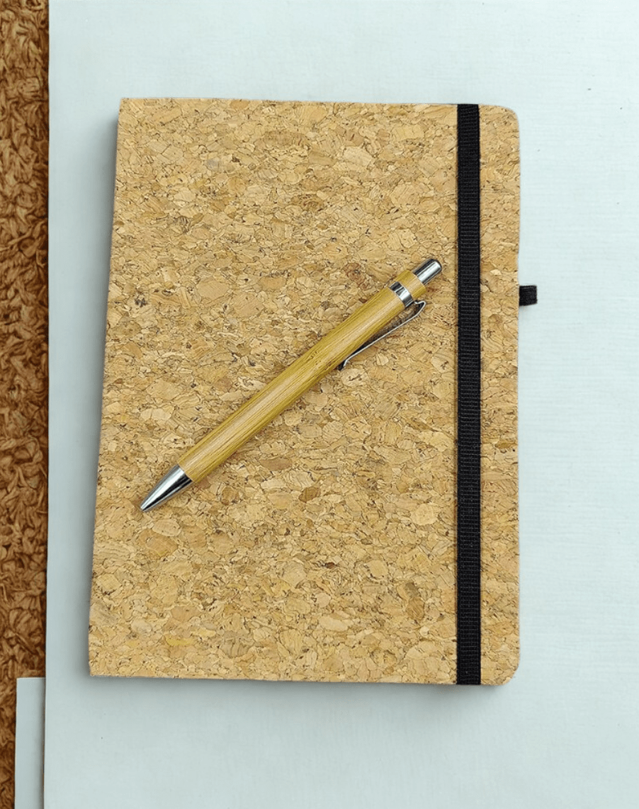 Cork notebook with a pen on a light gray background