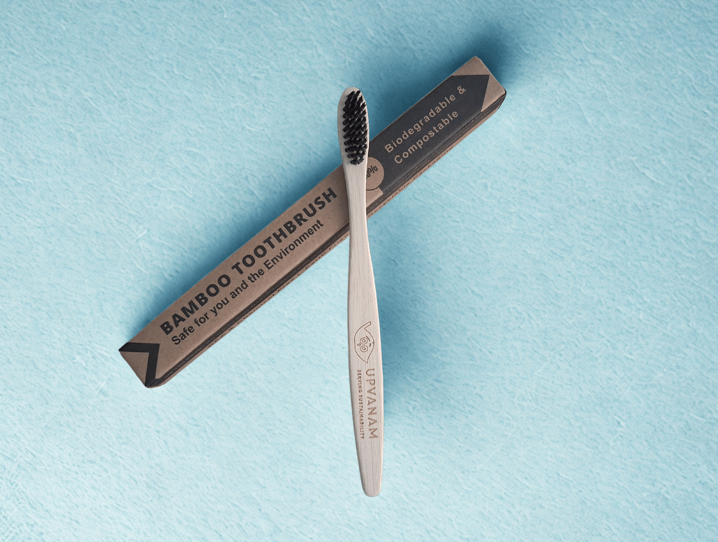 Bamboo toothbrush with eco friendly packaging on a light blue background