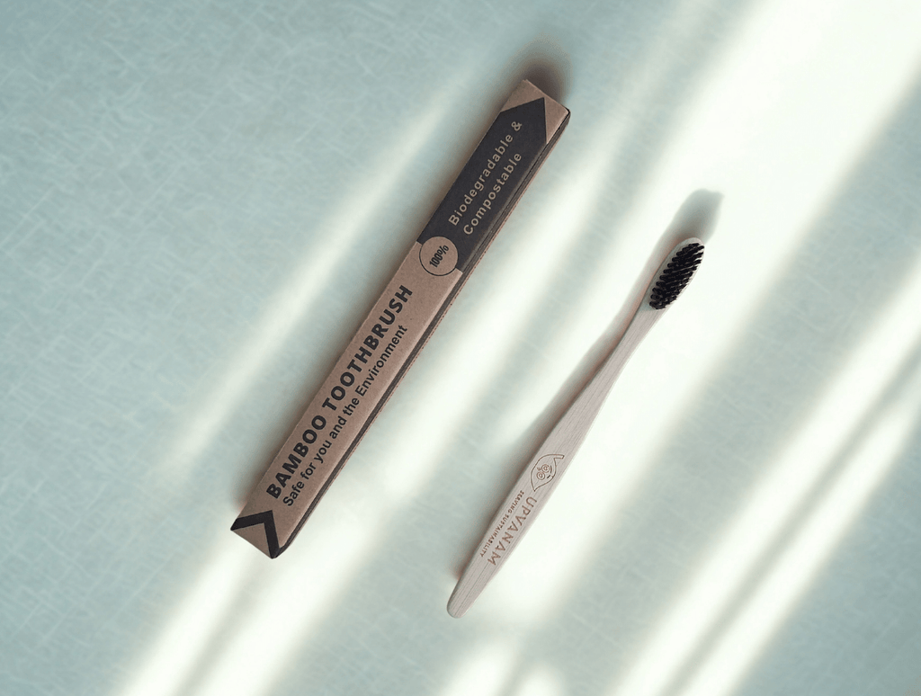 Bamboo toothbrush and eco friendly packaging on a light background