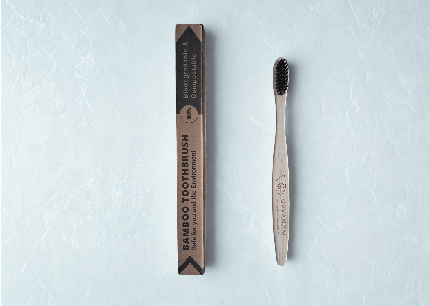 Bamboo toothbrush with eco friendly packaging on a light blue textured background