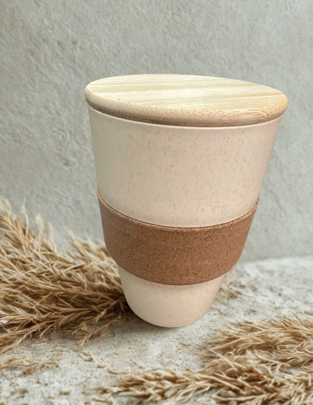 wheat straw coffee mug with bamboo lid on a textured surface